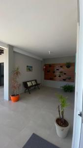 ein Wohnzimmer mit einer Bank und Topfpflanzen in der Unterkunft Pousada Encantos do Sul in Pinheira