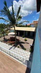uma vista a partir de uma varanda de um resort com uma palmeira em Pousada Encantos do Sul em Pinheira