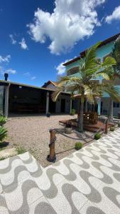 a fire hydrant in front of a building with a palm tree at Pousada Encantos do Sul in Pinheira