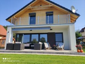 a house with a patio and chairs in front of it at New House Mazury in Sorkwity