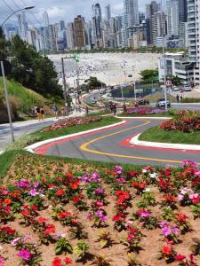 una carretera con flores al lado de una playa en Casa Área Central, en Balneário Camboriú