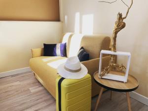 Habitación con sofá y sombrero en una mesa en Le Mas des Ecureuils en Aix-en-Provence