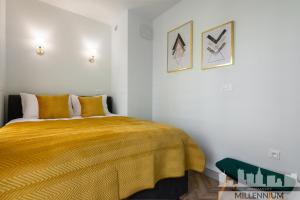 una camera con un letto con una coperta gialla di Millennium Port Gold a Varsavia