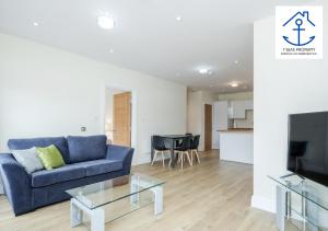 a living room with a blue couch and a table at Luxury 2 Bed Apartment by 7 Seas Property Serviced Accommodation Maidenhead with Parking and Wifi in Maidenhead