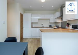 a kitchen with white cabinets and a counter top at Luxury 2 Bed Apartment by 7 Seas Property Serviced Accommodation Maidenhead with Parking and Wifi in Maidenhead