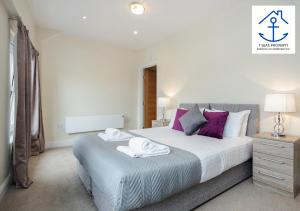 a bedroom with a large bed with towels on it at Luxury 2 Bed Apartment by 7 Seas Property Serviced Accommodation Maidenhead with Parking and Wifi in Maidenhead