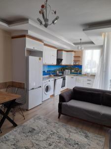 a living room with a couch and a kitchen at Çınar Residance in Demre