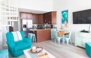 a living room with a blue chair and a kitchen at Grand Beach Resort Penthouse 1 in Gulf Shores