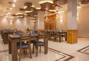 una grande sala da pranzo con tavoli e sedie in legno di The Bodhi Tree a Leh