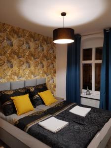 um quarto com uma cama grande e almofadas amarelas em Apartament Przy Placu Piastowskim em Jelenia Góra