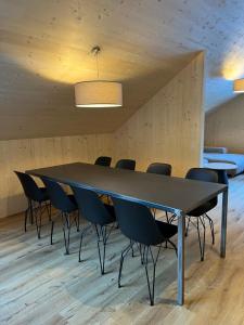 uma sala de conferências com uma mesa preta e cadeiras em SMART Apartments Mellau em Mellau