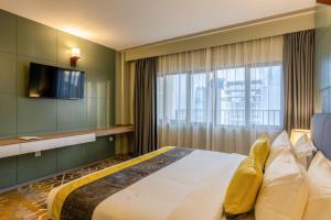 una camera con un grande letto e una TV di Manhattan Business Hotel, Male a Città di Malé