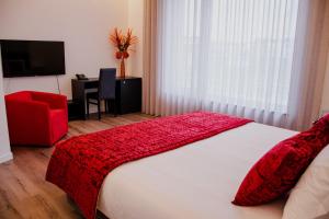 Un dormitorio con una cama con una manta roja. en 5ª Vigia en Porto de Mós