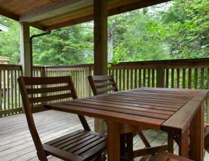 a wooden table and chairs on a wooden deck at Reef Point Cottages in Ucluelet