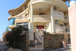 un gran edificio blanco con un gran balcón en Resort altayar Villa altayar 1 Aqua Park with Sea View en Sidi Krir 
