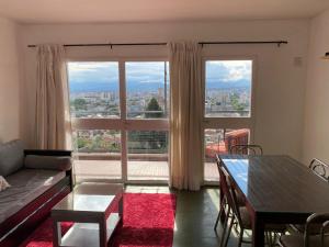 a living room with a table and a large window at Balcones de Salta in Salta