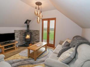 a living room with a couch and a fireplace at Hallgarth Farm Holiday Lodge in Pershore