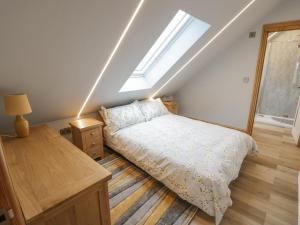 a bedroom with a bed and a skylight at Hallgarth Farm Holiday Lodge in Pershore
