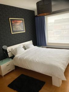 una camera da letto con un letto bianco e una finestra di Crea Els a Westerlo