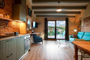 a kitchen and living room with a couch and a table at Priorat Aparthotel in Falset