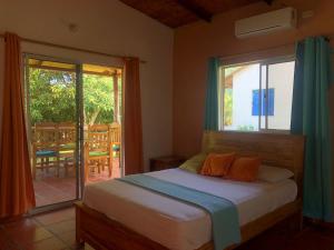 une chambre avec un lit et une porte coulissante en verre dans l'établissement Hotel Zaku Reserva Natural, à Palomino