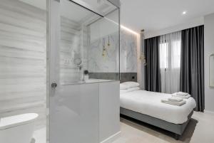 baño blanco con cama y ducha en EMBA ROOM, en Madrid