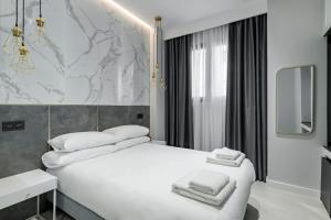 Un dormitorio con una cama blanca con toallas. en EMBA ROOM, en Madrid