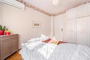 a bedroom with a white bed and a dresser at NALA Central Apartment in Arad