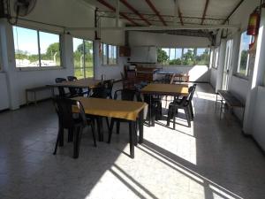- une salle à manger avec des tables, des chaises et des fenêtres dans l'établissement Complejo Turístico Imagine Victoria, à Victoria