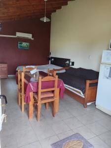 een kamer met een tafel en stoelen en een bed bij Complejo Turístico Imagine Victoria in Victoria