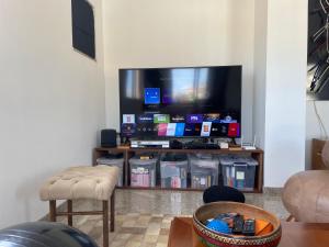 カシャンブにあるLindo apartamento em Caxambuのリビングルーム(大画面薄型テレビ付)