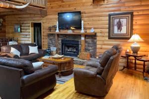 Una sala de estar con muebles de cuero y chimenea. en Cozy Trenton Cabin with Spa about 15 Mi to Lookout Mtn!, en Trenton