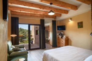 ein Schlafzimmer mit einem Bett und einer Glasschiebetür in der Unterkunft Priorat Aparthotel in Falset