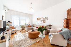 a living room with two couches and a table at NALA Central Apartment in Arad