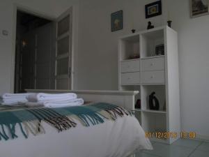 a white bedroom with a bed and a dresser at Praça do Chile apartment in Lisbon
