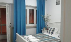 a bedroom with a bed with blue curtains at Praça do Chile apartment in Lisbon