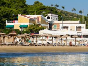 a beach with tables and umbrellas and the water at Hotel Vela Velo Club Vieste in Vieste