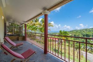 a balcony with chairs and a view of the ocean at Vert Ocean in Le Marin