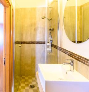 a bathroom with a sink and a shower with a mirror at Hotel Vela Velo Club Vieste in Vieste