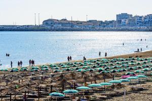 a bunch of umbrellas and chairs on a beach at Hotel Vela Velo Club Vieste in Vieste