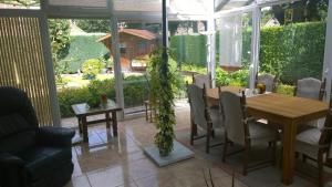 un giardino d'inverno con tavolo e sedie in legno e una sala da pranzo di Biker-Stop a Lathen