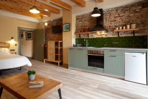 a kitchen with green cabinets and a bed in a room at Priorat Aparthotel in Falset