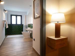 ein Badezimmer mit einem WC und einer Lampe auf dem Tisch in der Unterkunft Priorat Aparthotel in Falset