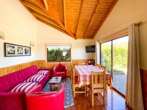 a living room with a red couch and a table at Cabaña Ayekantun Futrono in Futrono