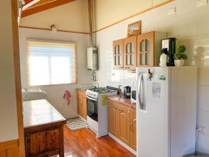 a kitchen with a white refrigerator and wooden cabinets at Cabaña Ayekantun Futrono in Futrono