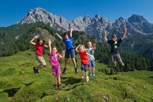 a group of children jumping on a mountain at Ferienwohnungen Mitterer in Waidring