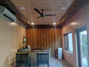 un soggiorno con ventilatore a soffitto e bancone di Corbett Comfort Lodge a Garjia