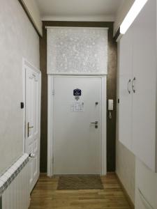 a hallway with a white door with a sign on it at Knez Mihailova Apartman in Belgrade
