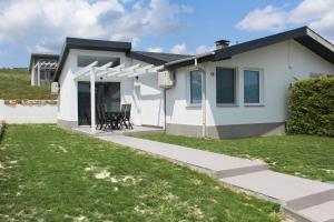 a white house with a porch and a patio at Holiday Villapark - Seaview Albena - Rogachevo - Bulgaria in Rogachevo