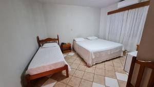 una camera con 2 letti e un pavimento piastrellato di Sevilha Park Hotel a Colorado